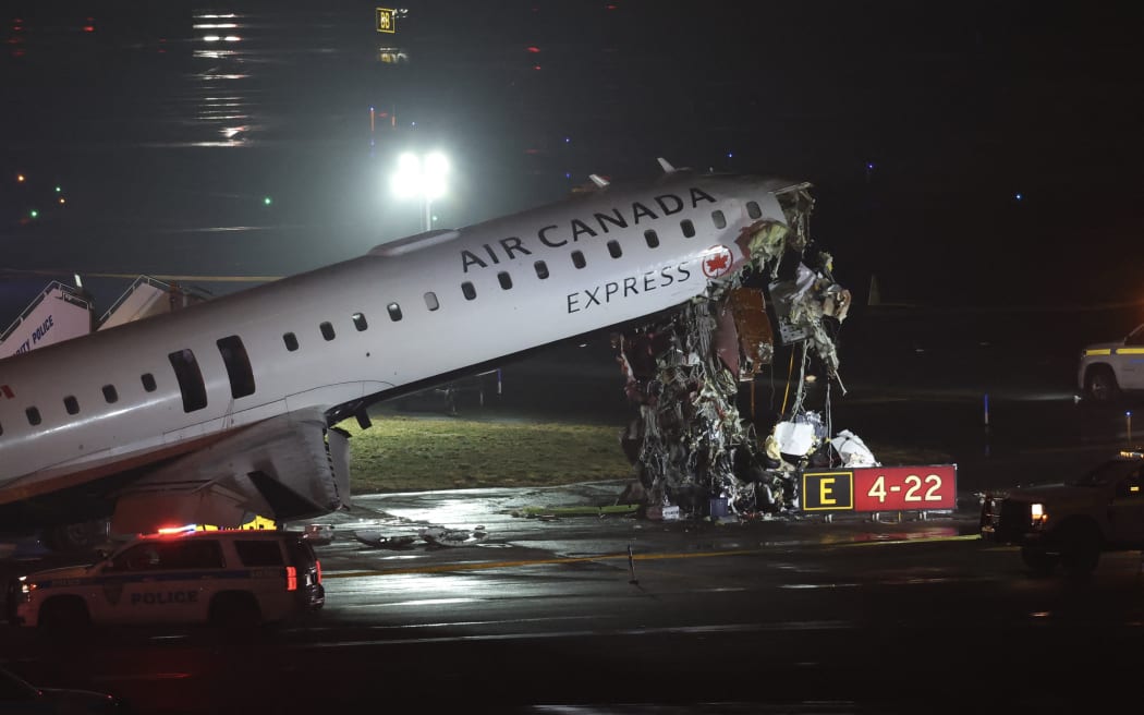 An Air Canada Express CRJ-900 sits on the runway after colliding with a Port Authority fire truck at LaGuardia Airport in New York, on March 23, 2026. Air Canada Express flight AC8646 originated from Montreal and collided with the fire truck during landing. (Photo by ANGELA WEISS / AFP)