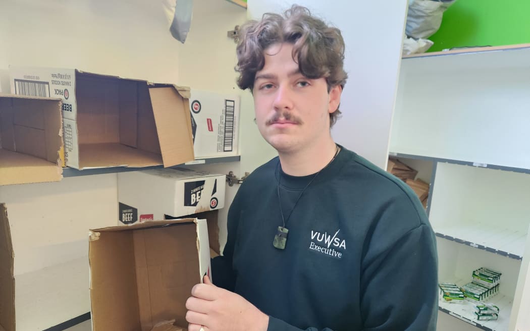 Victoria University of Wellington Students Association president Aidan Donoghue displays empty boxes at the association's foodbank.
