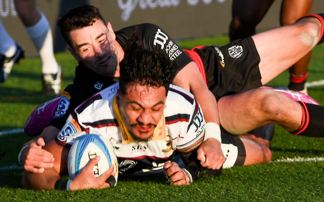 Tanielu Tele'a of the Highlanders scores a try in the tackle of Will Jordan of the Crusaders during the Super Rugby Pacific match.