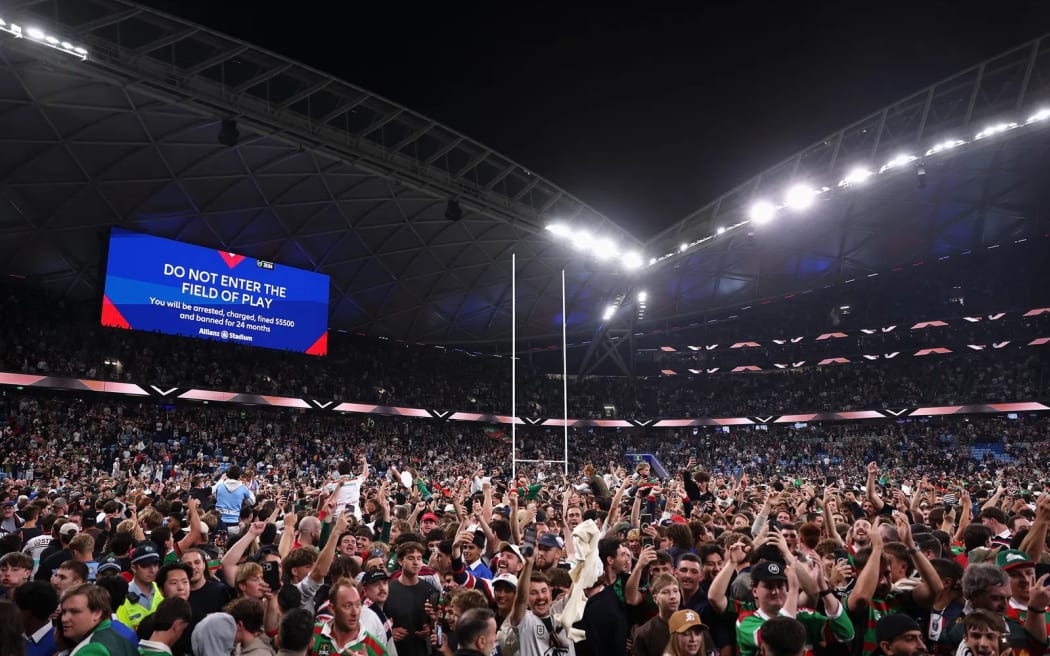 Fans storm the field to celebrate South Sydney's Alex Johnston breaking the NRL try scoring record.