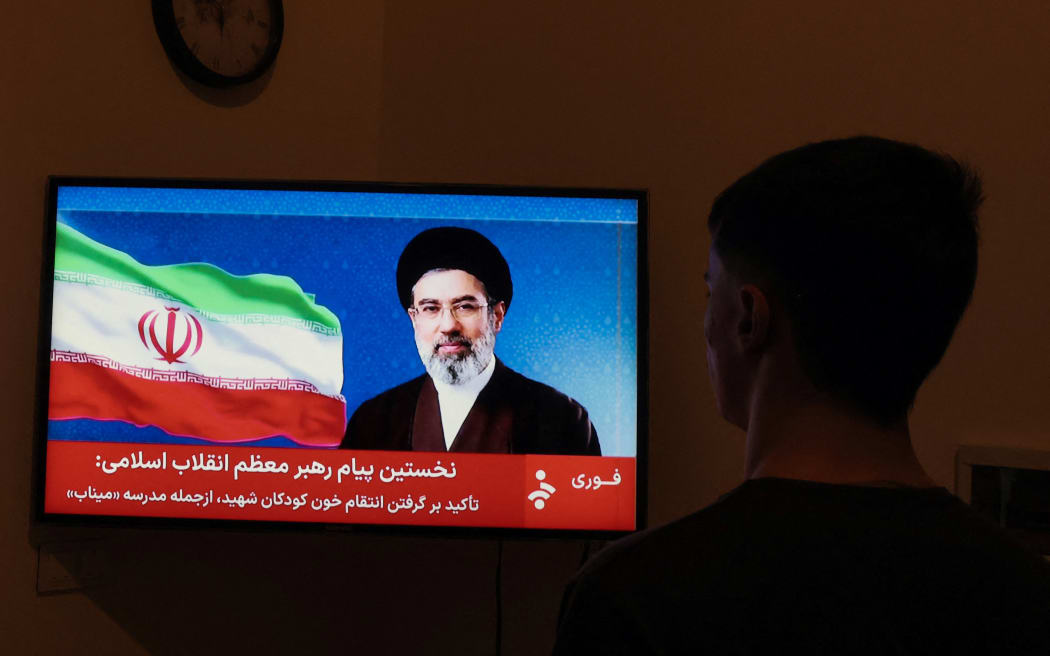A man watches a televised statement by Iran's new supreme leader Mojtaba Khamenei on March 12, 2026. Iran's new supreme leader ordered the vital Strait of Hormuz oil shipping lane to remain closed on March 12, while US President Donald Trump said stopping the Islamic republic's "evil empire" was more important than crude prices. Ayatollah Mojtaba Khamenei, who was reportedly injured in an air strike, has yet to appear publicly since his nomination as supreme leader, and his defiant message was read by a newscaster on state television.