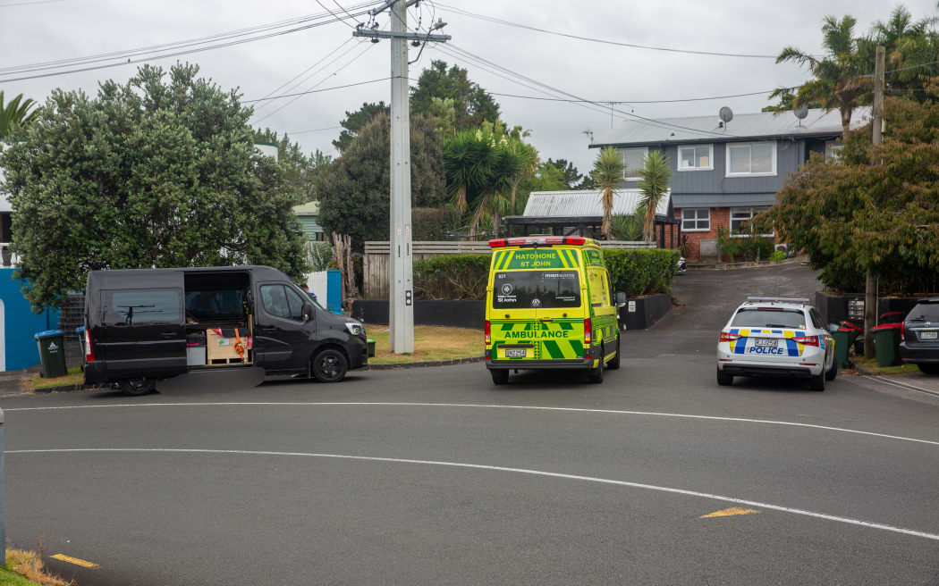 Police are present at a location in Mt Albert where a person is believed to have died in unknown circumstances. A body lays in the gutter on the other side of the black van.