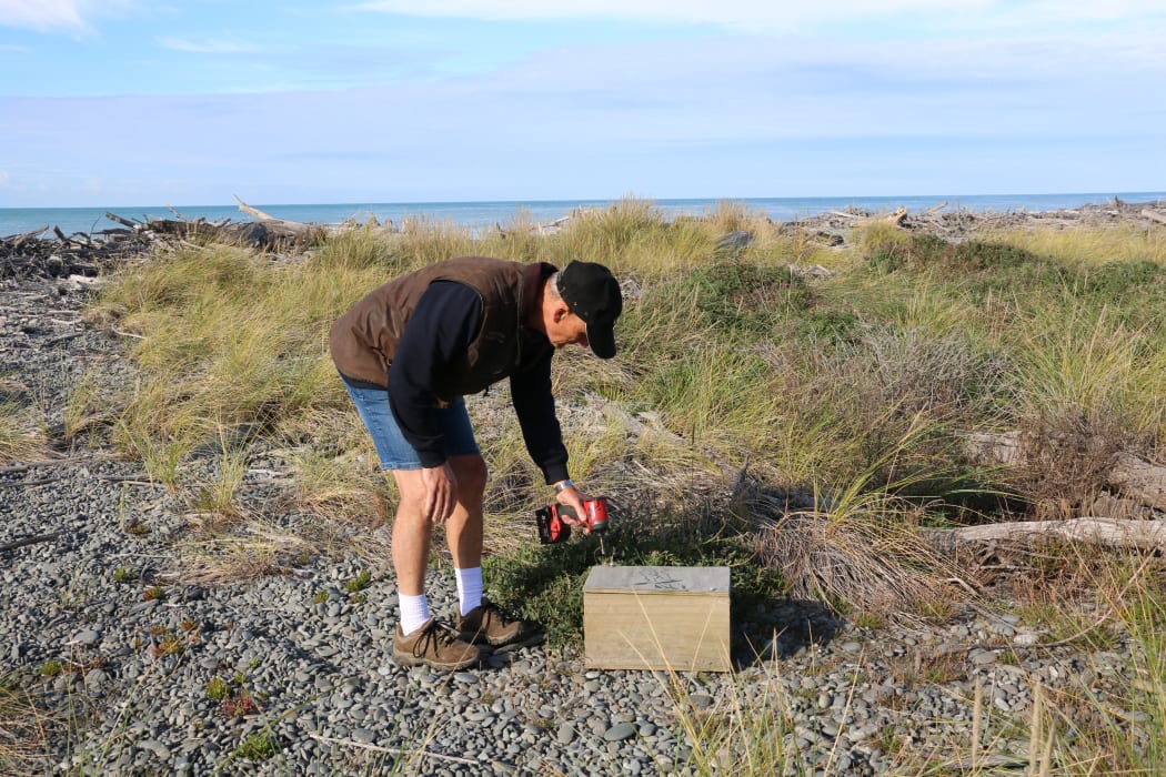 Ken Body unscrews a trap to check what's inside.