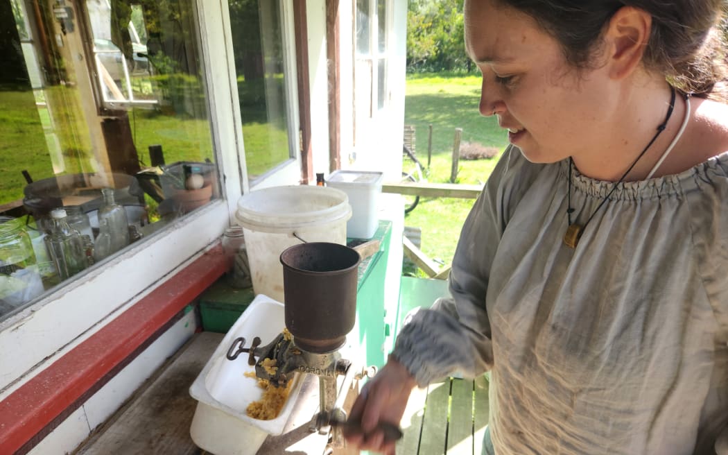 Marissa grinding maize kernels on the verandah