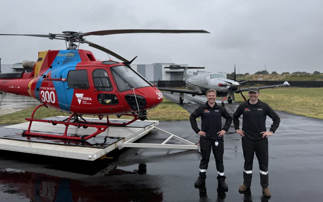 Two brothers Henry and Edward Phelps, in uniform, standing on the tarmac beside a helicopter
