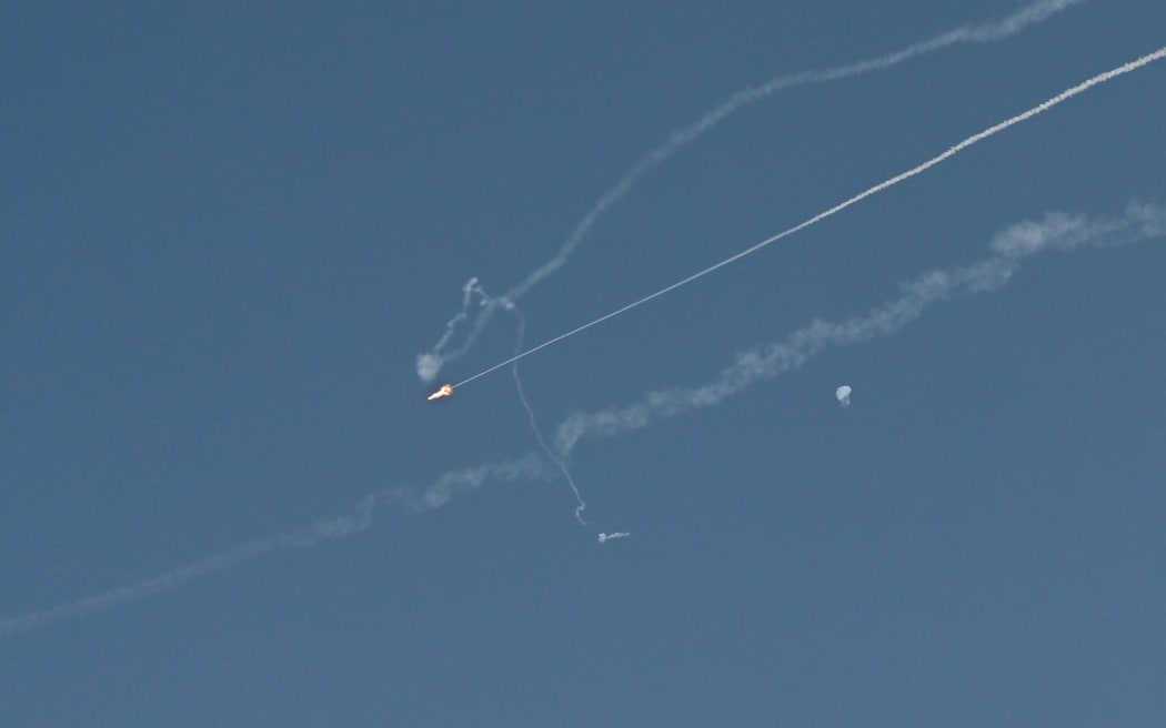 Explosions from the interception of an Iranian projectile are seen in the sky over Dubai on March 1, 2026. Fresh blasts were heard across the Gulf cities of Dubai, Doha and Manama on Sunday morning after a day of Iran strikes in the region in retaliation for US and Israeli attacks. (Photo by Giuseppe CACACE / AFP)