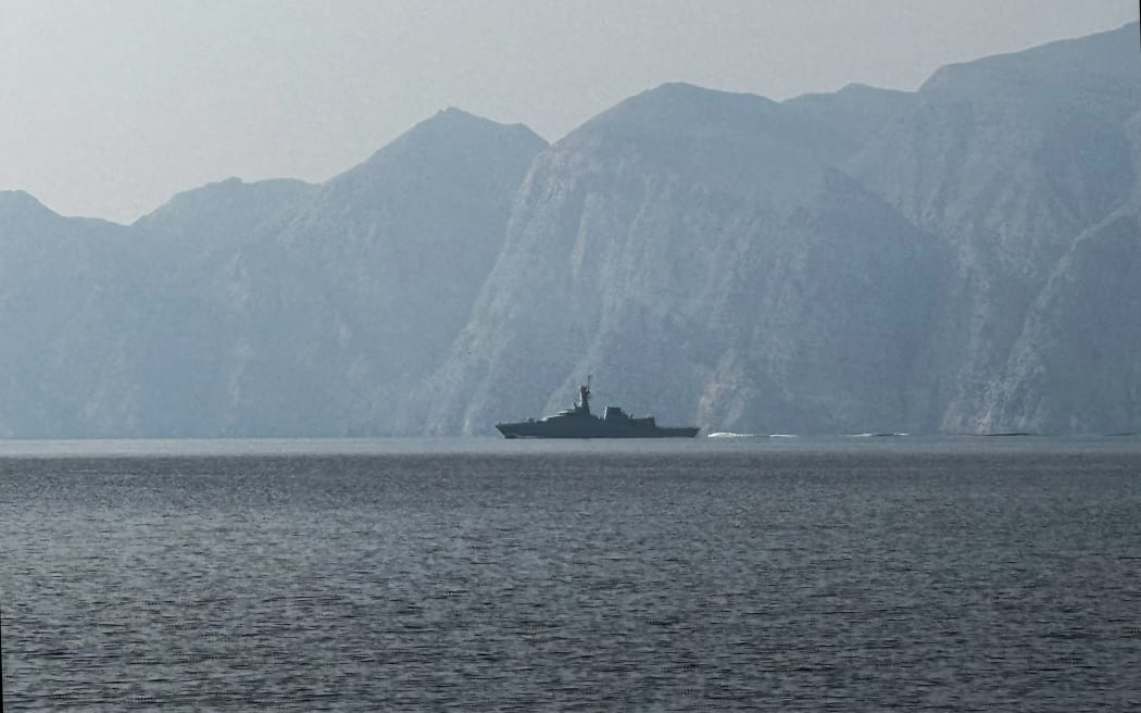 A navy vessel is seen sailing in the Strait of Hormuz, a vital waterway through which much of the world's oil and gas passes on March 1, 2026. Two ships were attacked in the Strait of Hormuz on March 1, maritime security agencies said, as Iran pressed a second day of strikes in response to US-Israeli military strikes on Iran killing it's supreme leader. (Photo by Sahar AL ATTAR / AFP)