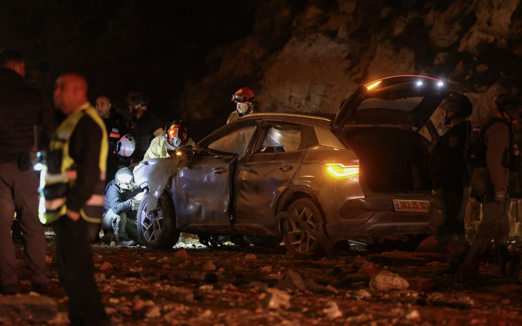Israel security forces inspect a destroyed car after a missile struck a road in Jerusalem on 1 March.