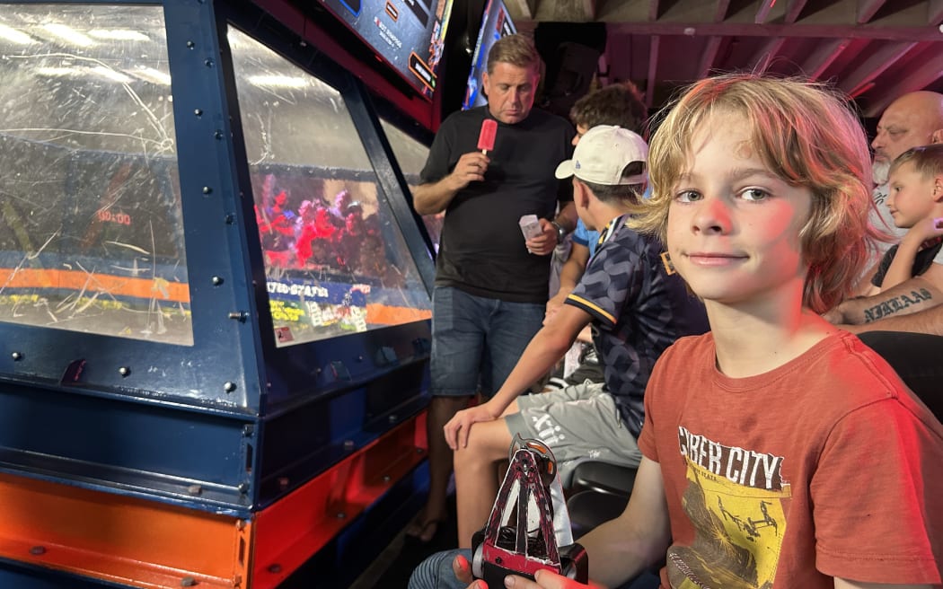 Picture of a boy posing with a rectangular shaped robot.