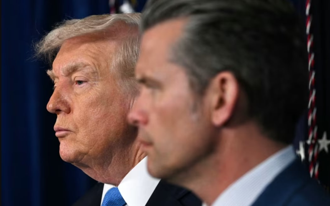 US President Donald Trump and US Secretary of Defense Pete Hegseth look on as Chairman of the Joint Chiefs of Staff General Dan Caine (out of frame) speaks to the press following US military actions in Venezuela, at Trump's Mar-a-Lago residence in Palm Beach, Florida, on January 3, 2026.