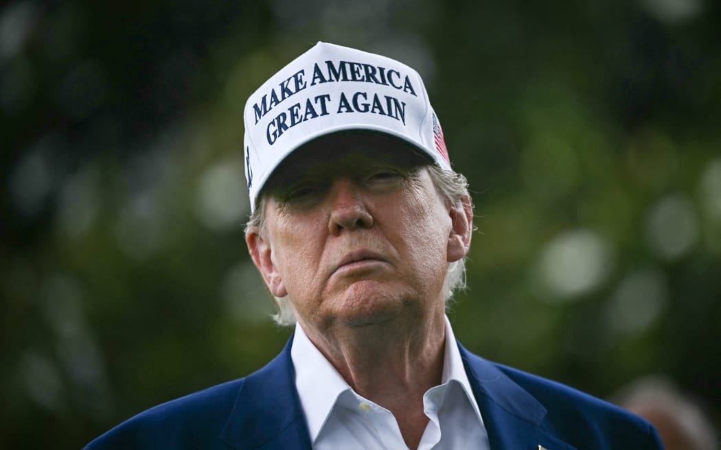 US President Donald Trump speaks to the press as workers install a large flag pole on the South Lawn of the White House in Washington, DC on June 18, 2025. President Trump left the question of whether the United States will join Israeli strikes on Iran up in the air Wednesday, as he said that Tehran had reached out to seek negotiations. "I may do it, I may not do it. I mean, nobody knows what I'm going to do," Trump told reporters as he supervised the installation of a new flagpole on the White House South Lawn. (Photo by Brendan SMIALOWSKI / AFP)