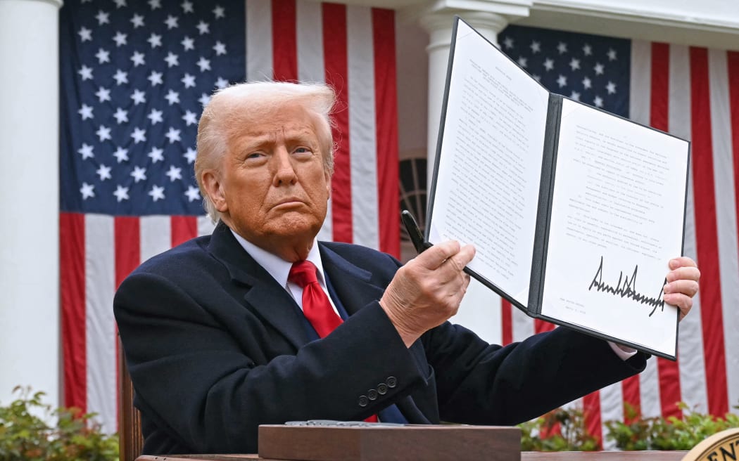 US President Donald Trump holds a signed executive order after delivering remarks on reciprocal tariffs during an event in the Rose Garden entitled "Make America Wealthy Again" at the White House in Washington, DC, on April 2, 2025. Trump geared up to unveil sweeping new "Liberation Day" tariffs in a move that threatens to ignite a devastating global trade war. Key US trading partners including the European Union and Britain said they were preparing their responses to Trump's escalation, as nervous markets fell in Europe and America. (Photo by SAUL LOEB / AFP)