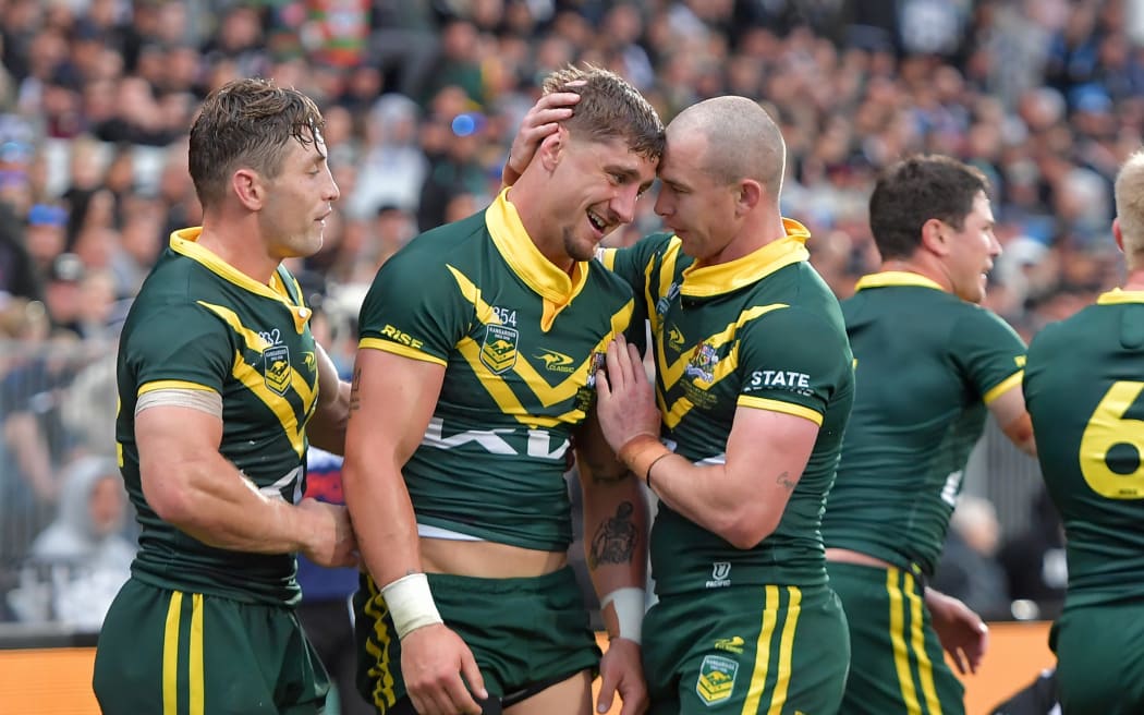 The Kangaroos celebrate a try for Zac Lomax (C) against the Kiwis.