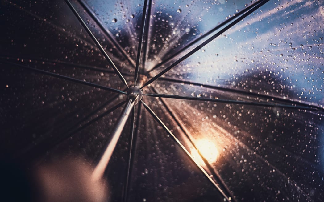Rain on an umbrella at night.