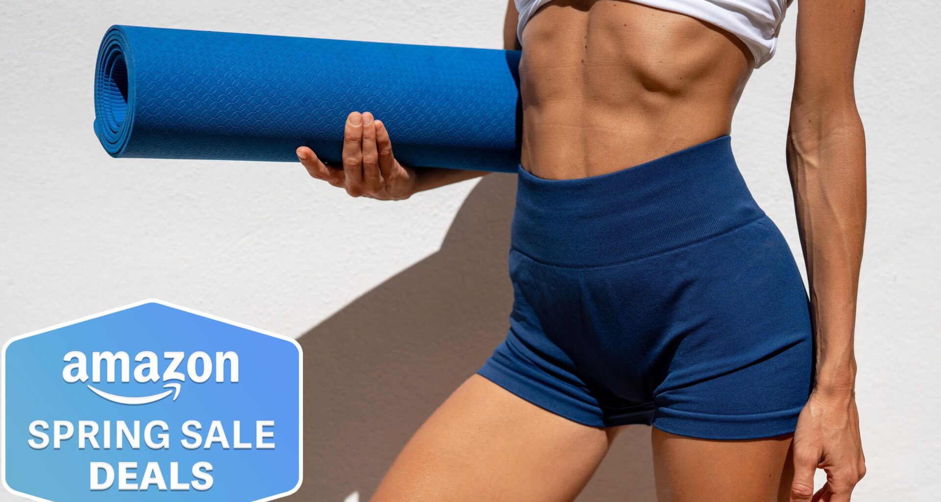 Woman holding a blue yoga mat wearing workout gear showing torso and legs only, Amazon Spring Sale badge bottom left