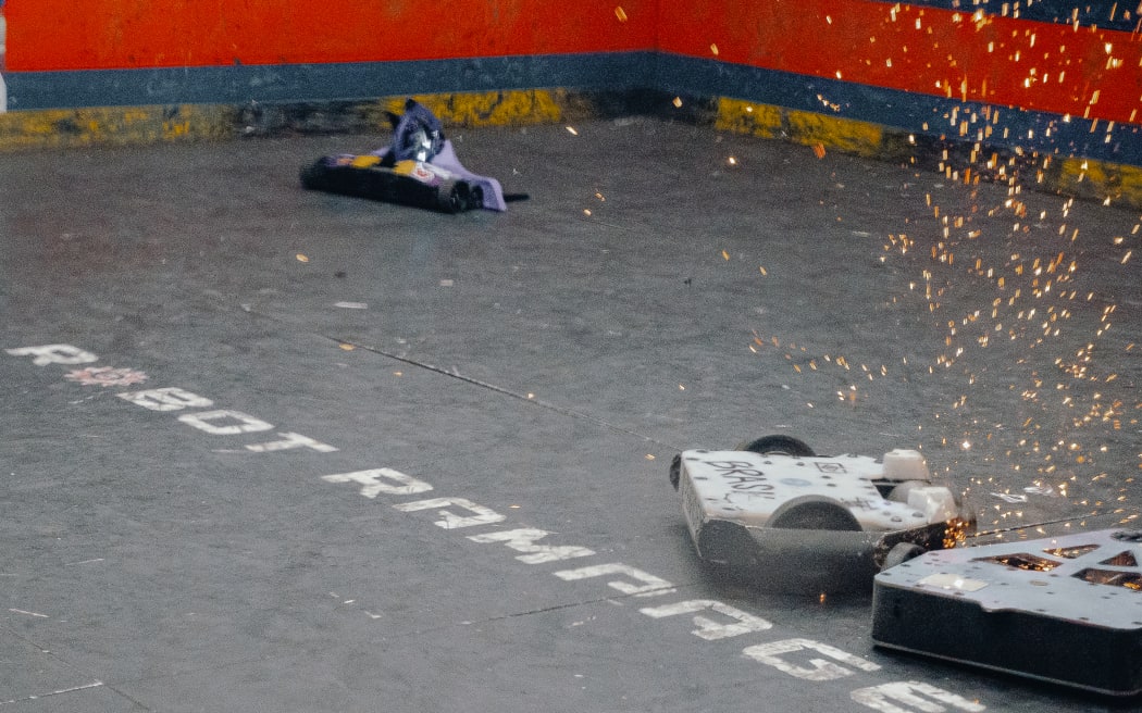 Picture depicting two robots clashing with each other and igniting sparks.