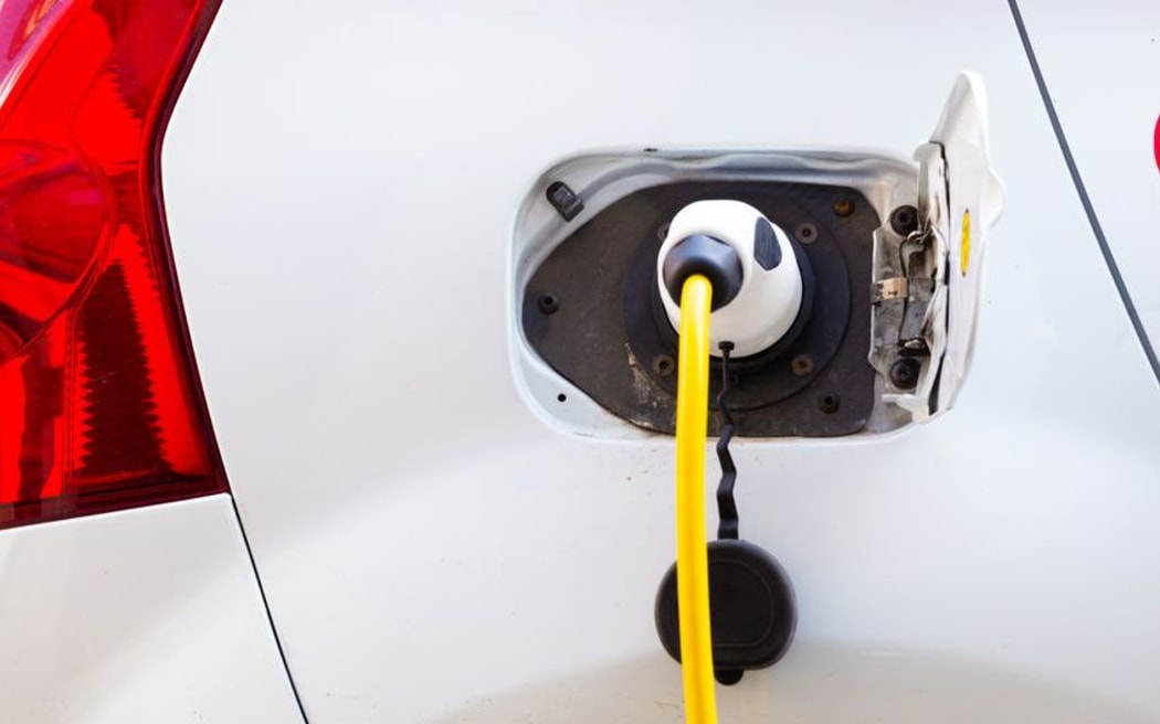 Detail power supply for electric car charging. Electric car charging station. Close up of the power supply plugged into an electric car being charged.