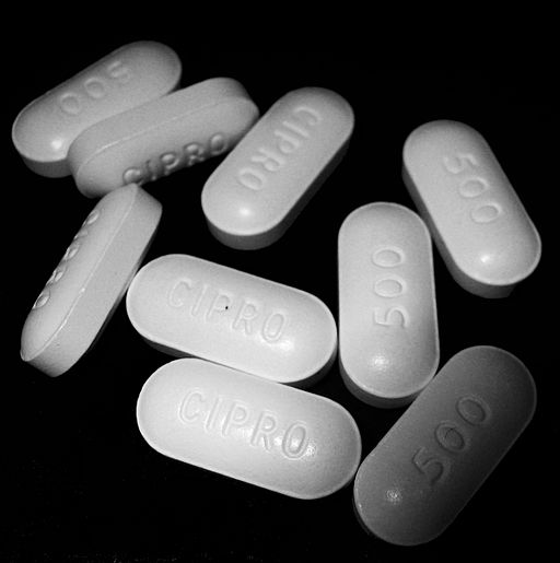 White ciprofloxacin tablets on black background