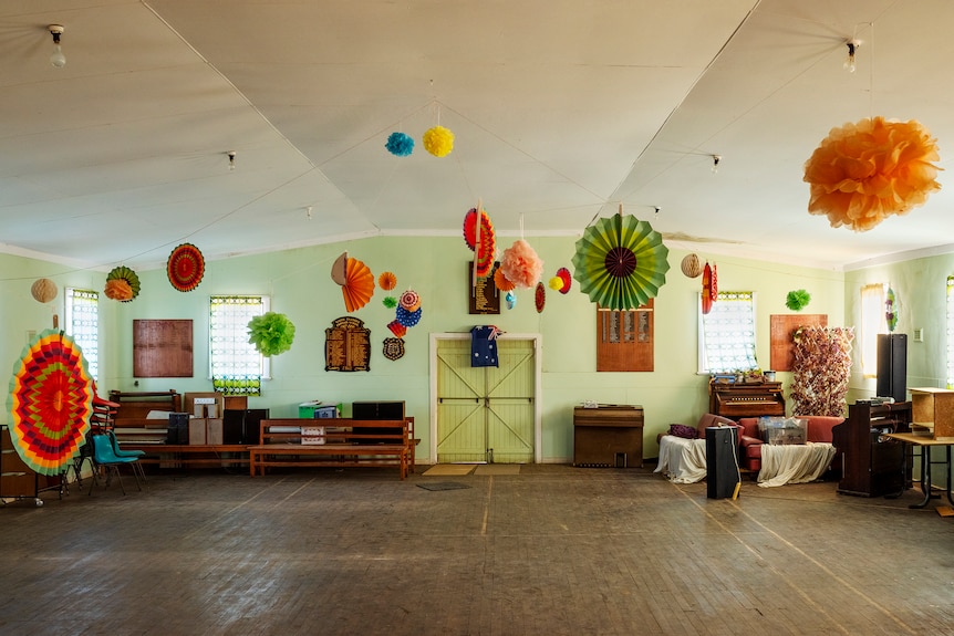 Empty country hall with bright paper decorations hanging from ceiling