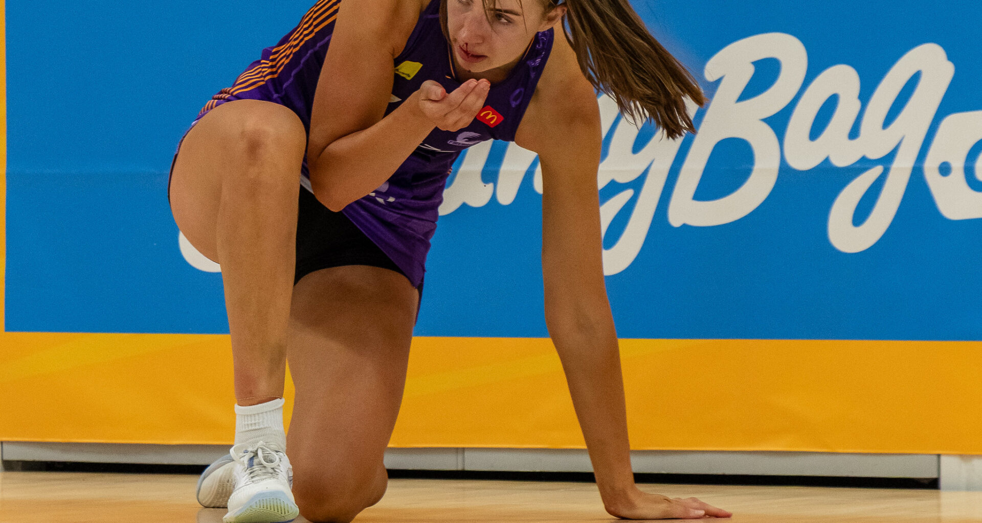 Kelly Jackson tries to catch the blood after coping a nose knock. Image: Simon Leonard