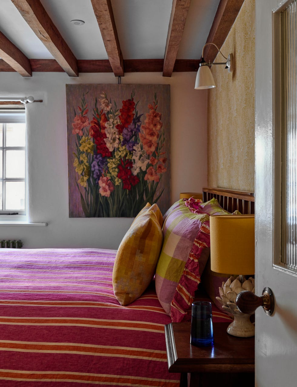 Cosy bedroom with floral artwork striped bedding and decorative elements cosy bedroom with floral artwork striped bedding and decorative elements