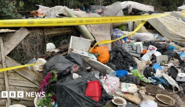 A pile of rubbish including mattresses, black bin bags is covered in yellow tape.