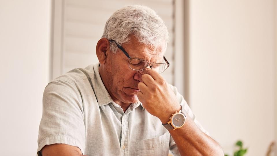 Worried retiree man sitting thinking.