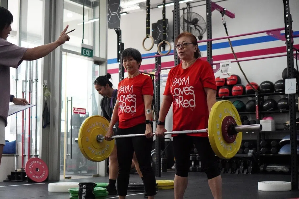 Ms Sharon Tan (left) and Ms Selina Chua doing partner barbell deadlifts at Rx Performance at Outram.
