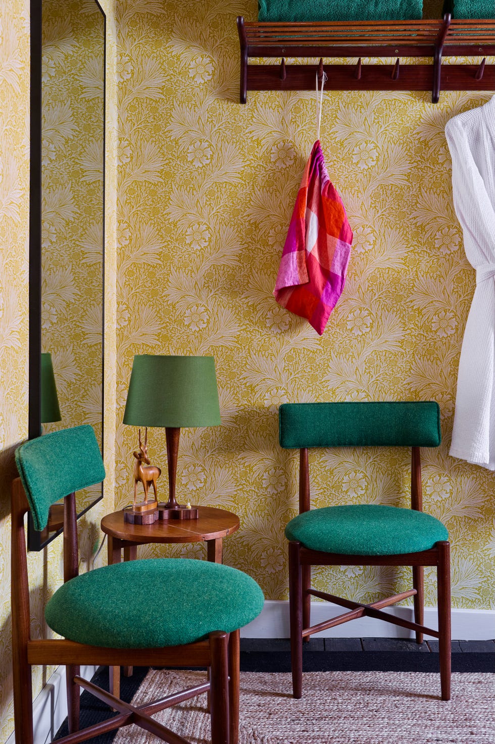 Cosy bedroom featuring green chairs a decorative lamp and a patterned wall cosy bedroom featuring green chairs a decorative lamp and a patterned wall