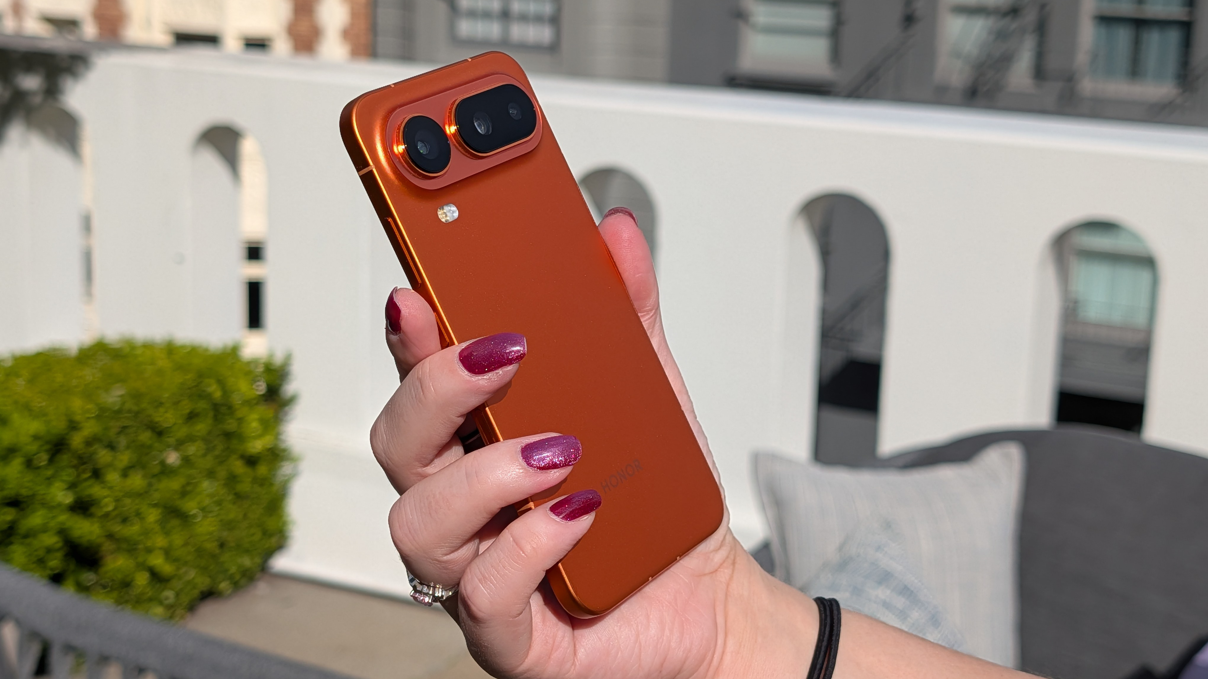 The Honor Magic 8 Pro Air in orange in the hand