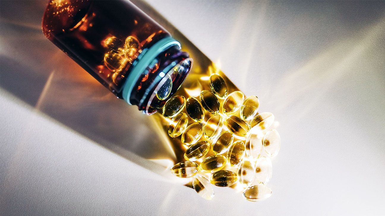 A bottle of vitamins spilling out on to a white surface