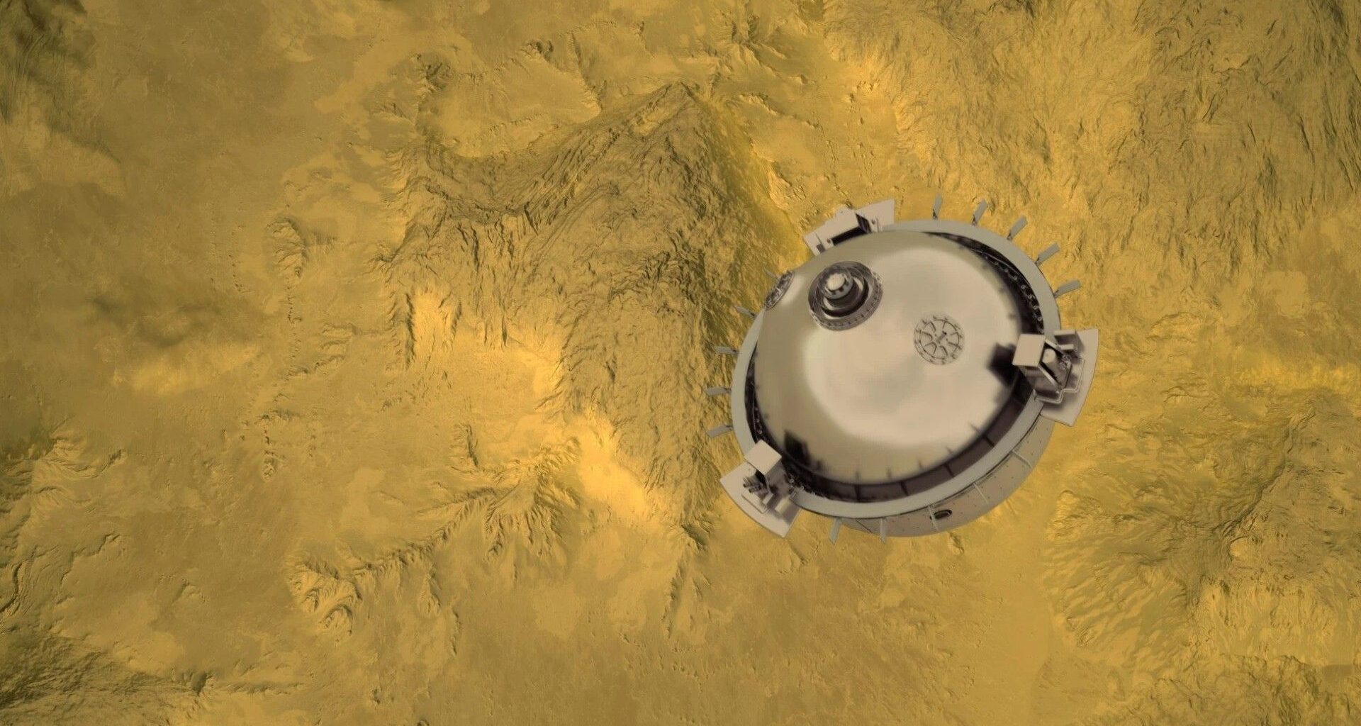 a silver spherical probe above a yellow-and-grey mountainous landscape, as seen from far above