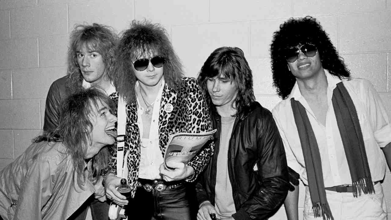 Yngwie Malmsteen posing for a backstage photograph with his solo band in 1986