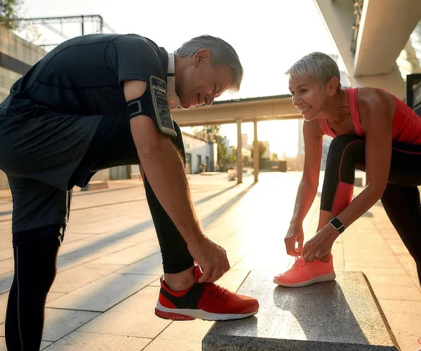 man and woman tying sneakers before exercising