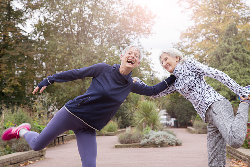 Senior women stretching legs in park.