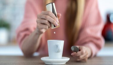 Close-up of woman hand throwing saccharin pills on coffee cup in the kitchen at home.