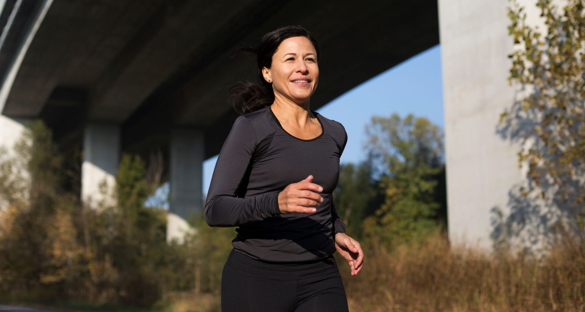Woman running confidently outside after doing Pilates for runners