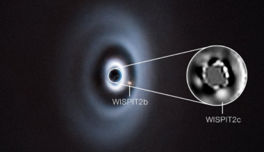 An object with gray wispy rings around. A small dot next to it says WISPIT 2b and an enlarged spot even closer to it (magnified in a boxout) says WISPIT 2c.