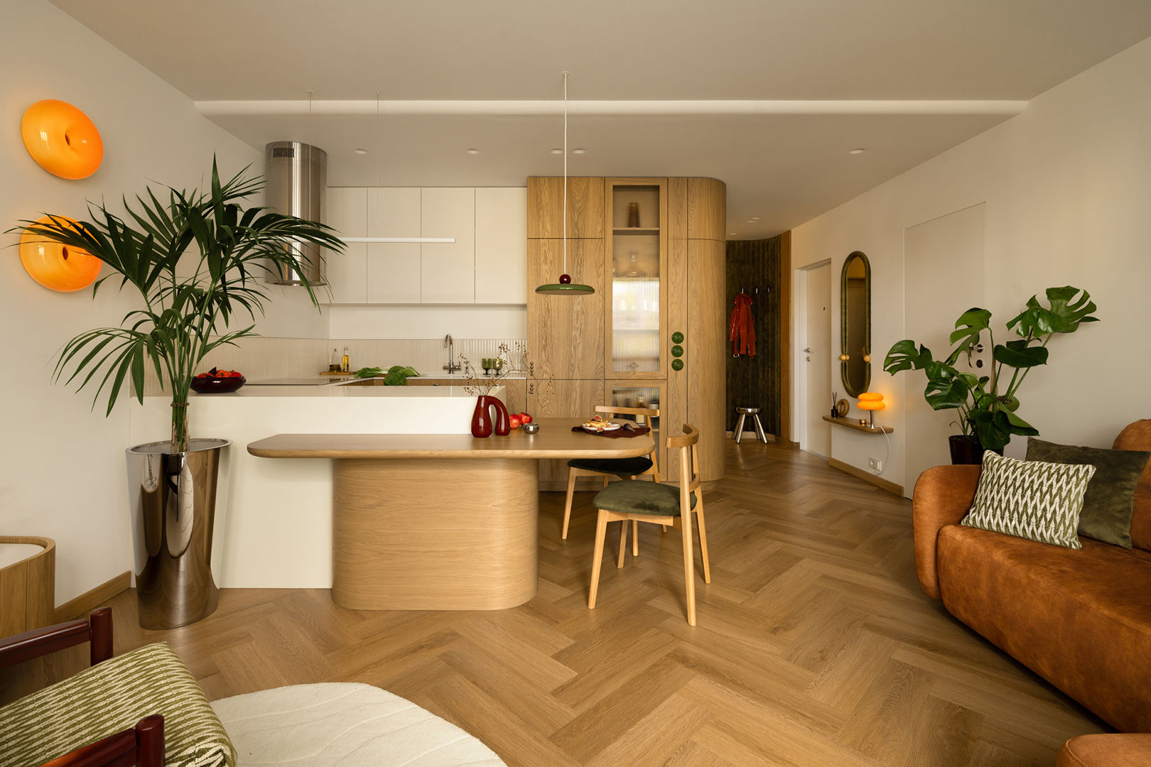 living room with wood floors, sofa, wood dining area, and white kitchen