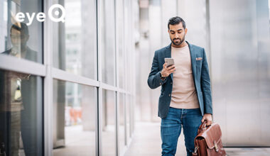 eyeQ businessman looking at stocks on smartphone