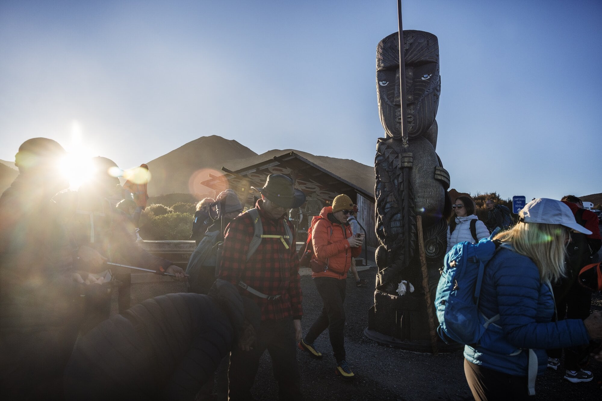 Walkers mingle under Te Ririō, the kaitiaki for those heading on to the Tongariro Alpine Crossing. Photo / Mike Scott