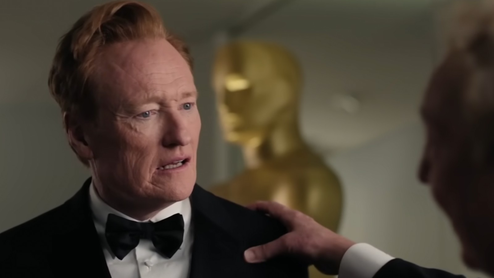 Conan O'Brien with a hand on his shoulder.