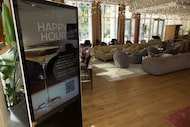 A sign advertises happy hour at Astra Kitchen + Lounge inside the Hall Arts Hotel on Friday,...