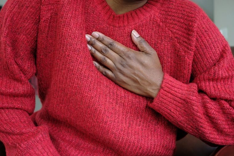Close-up of unrecognizable black woman holding her chest in pain