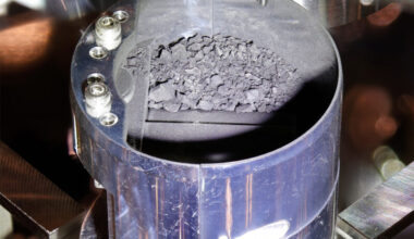 Life’s genetic code: Small chips of gray gravel and dust inside a blue metal cylinder.