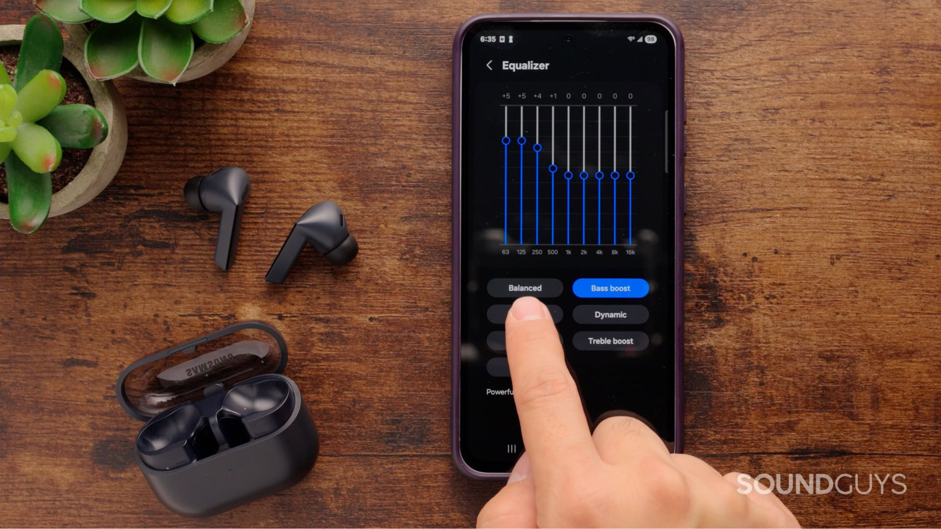 A photograph of the Samsung Galaxy Buds3 FE and a smartphone.