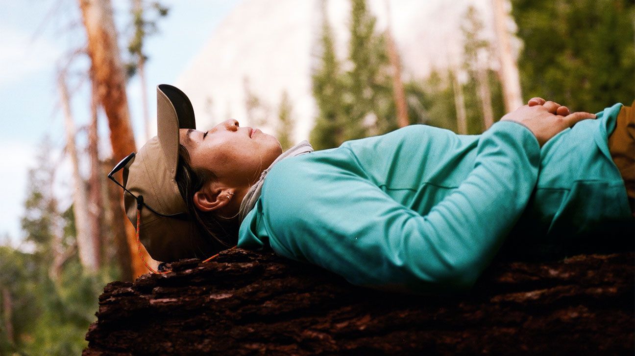 Hiker resting on tree outdoors