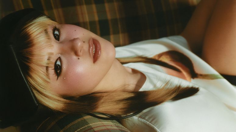 alysa liu lays on a couch 