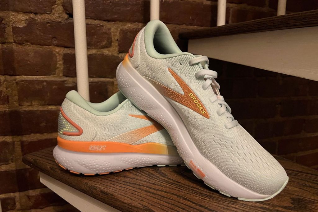 A pair of Brooks Ghost running shoes in light green and orange.