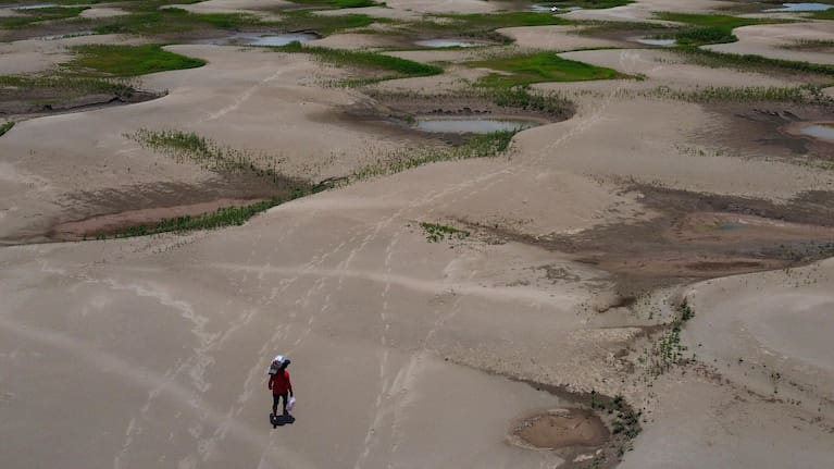 A resident of a riverside community carries food and containers of drinking water after being distributed due to the ongoing drought in Careiro da Varzea, Amazonas state, Brazil.